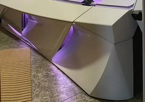 Solārija pamatne ar violeto apgaismojumu uz flīžu grīdas